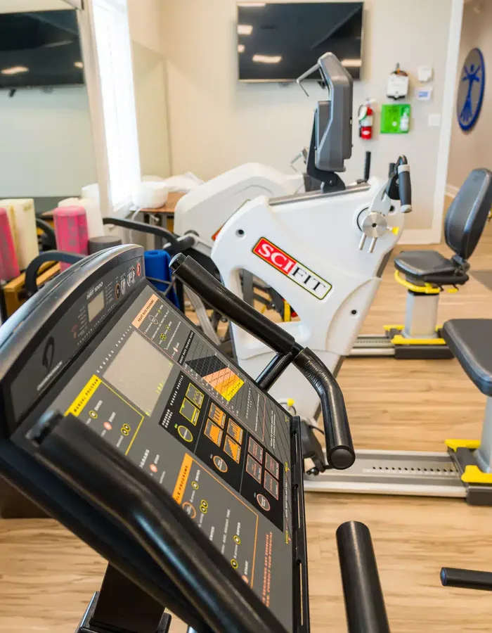 Close up of a treadmill console and a seated recumbent trainer in the adult therapy gym