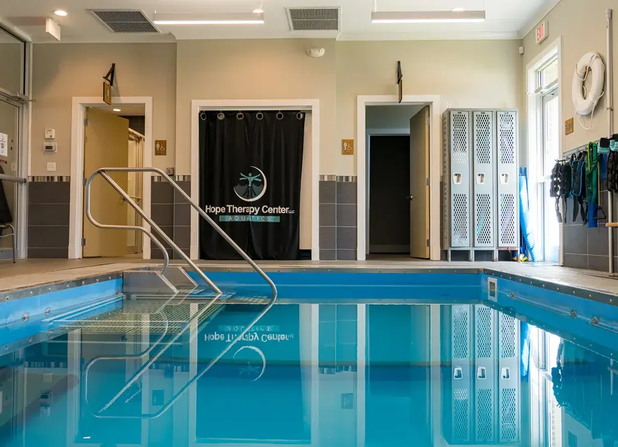 Indoor aquatic therapy pool at the Lake Charles clinic with stair entry, handrail and changing room lockers