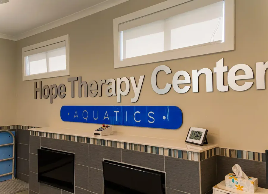 Hope Therapy Center Aquatics signage above the tiled wall of the indoor therapy pool room