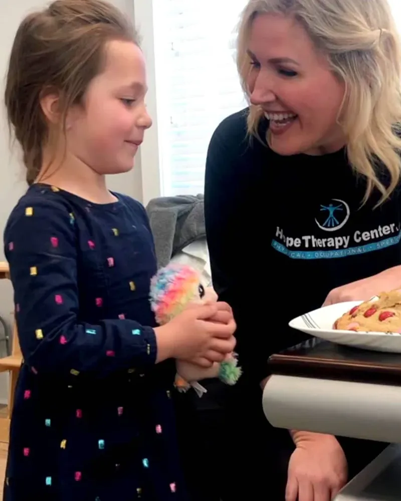 A therapist sharing a warm moment with a young patient at Hope Therapy Center
