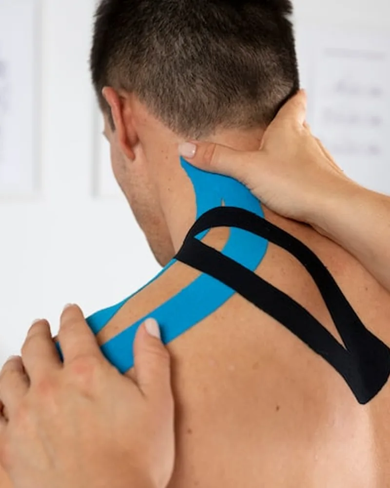 Licensed physical therapist applying kinesiology tape to a patient's knee in Lake Charles